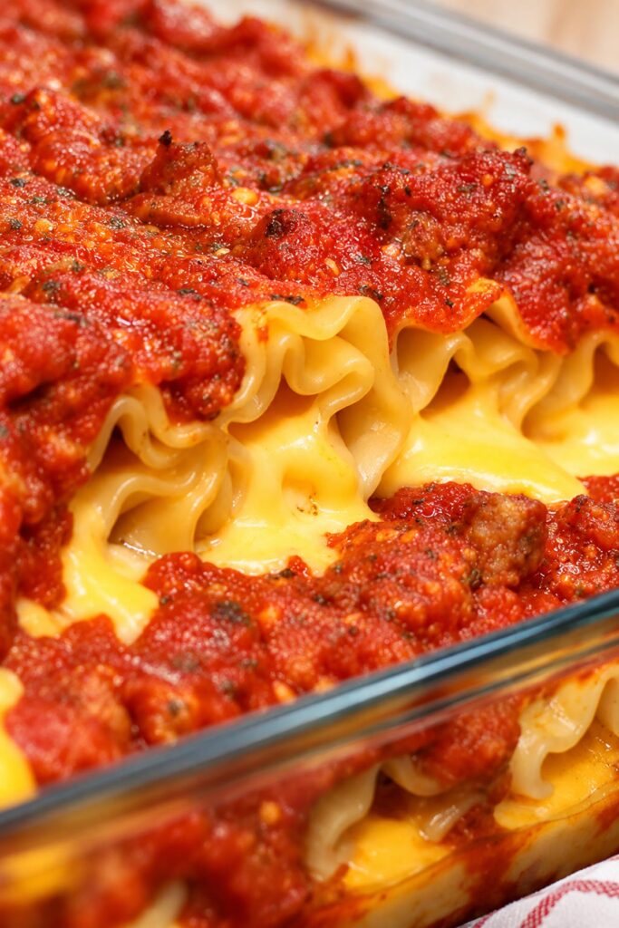 Close-up of baked Velveeta lasagna roll ups with gooey melted cheese, tender pasta noodles, and rich, homemade meat sauce.