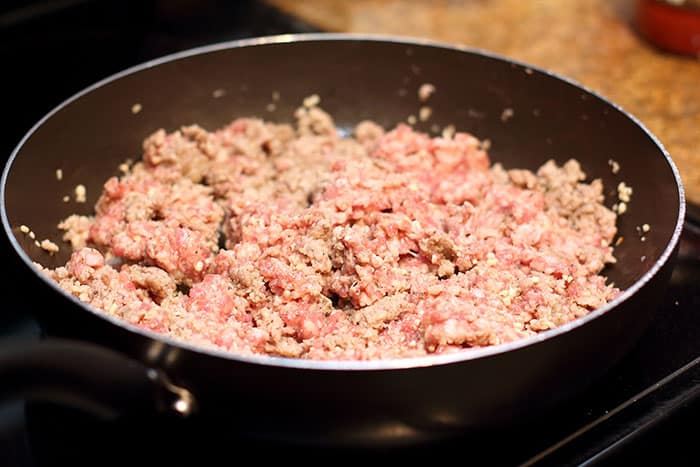 country sausage cooking in a large skillet