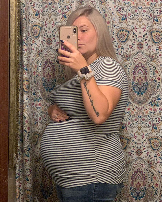 19 weeks pregnant woman showing off baby bump