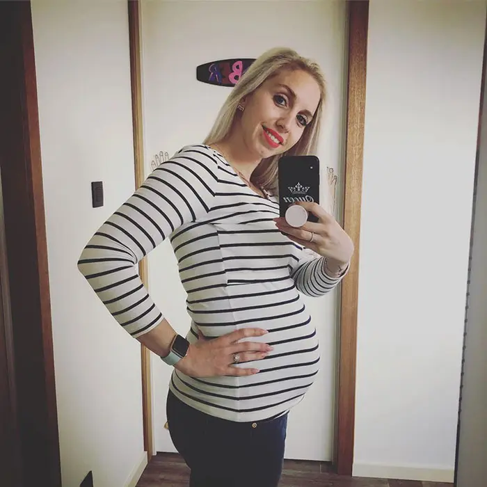 20 weeks pregnant woman showing off baby bump