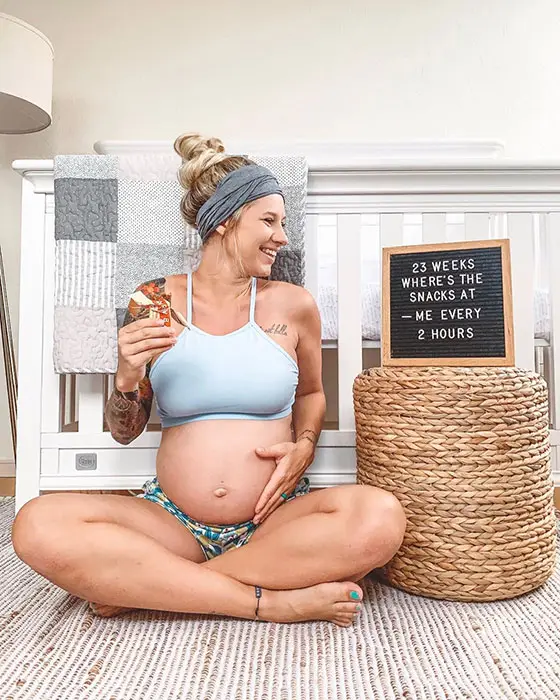 23 weeks pregnant woman showing off baby bump