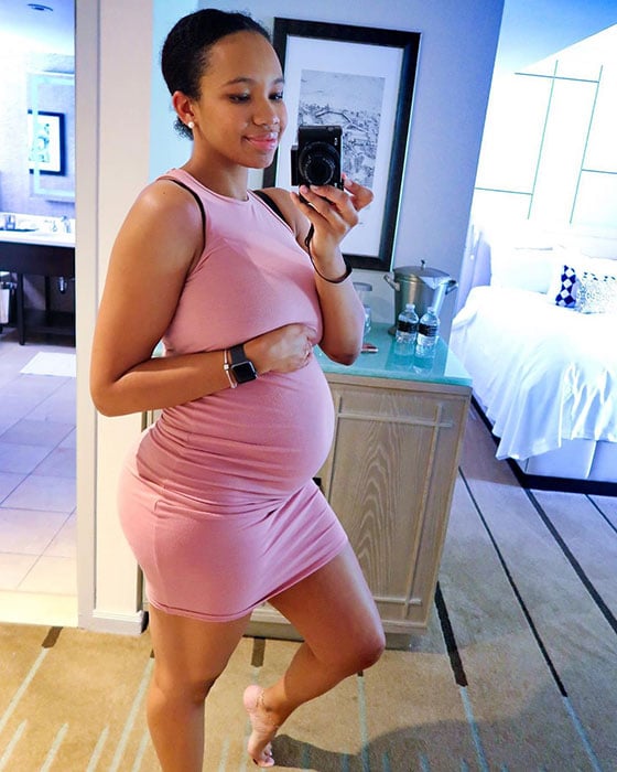 27 weeks pregnant woman showing off baby bump