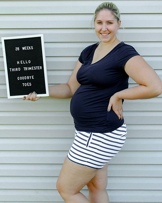 28 weeks pregnant woman showing off baby bump