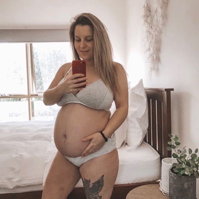 30 weeks pregnant woman showing off baby bump