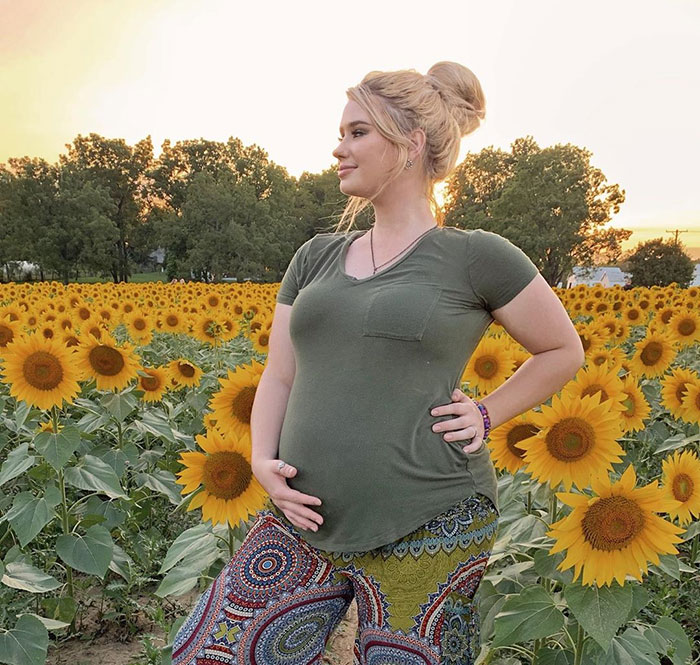 31 weeks pregnant woman showing off baby bump