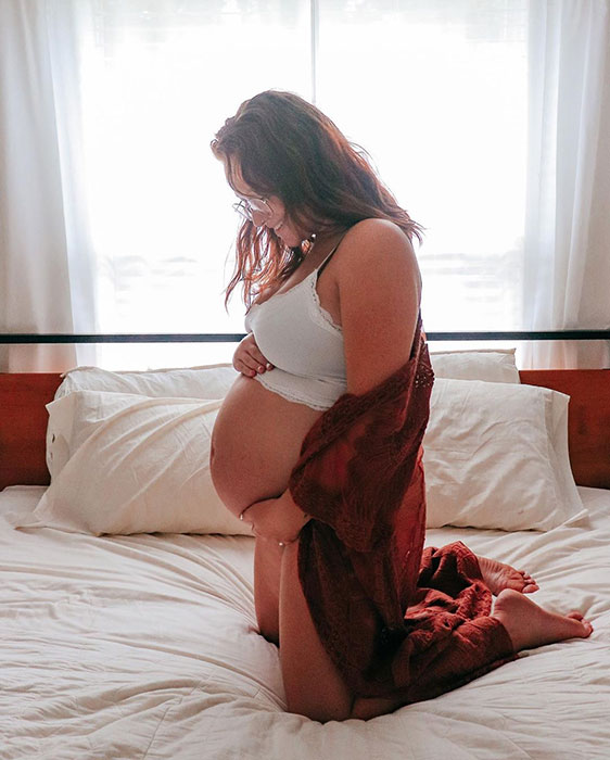 32 weeks pregnant woman showing off baby bump
