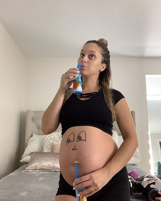 33 weeks pregnant woman showing off baby bump