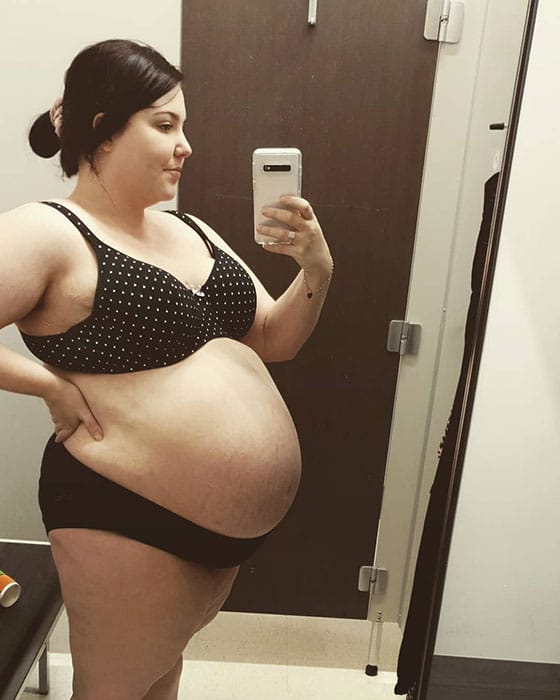 34 weeks pregnant woman showing off baby bump