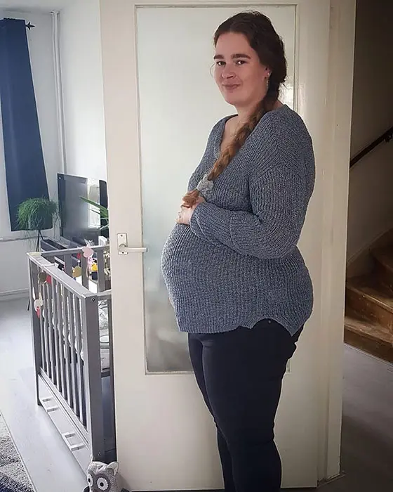 35 weeks pregnant woman showing off baby bump