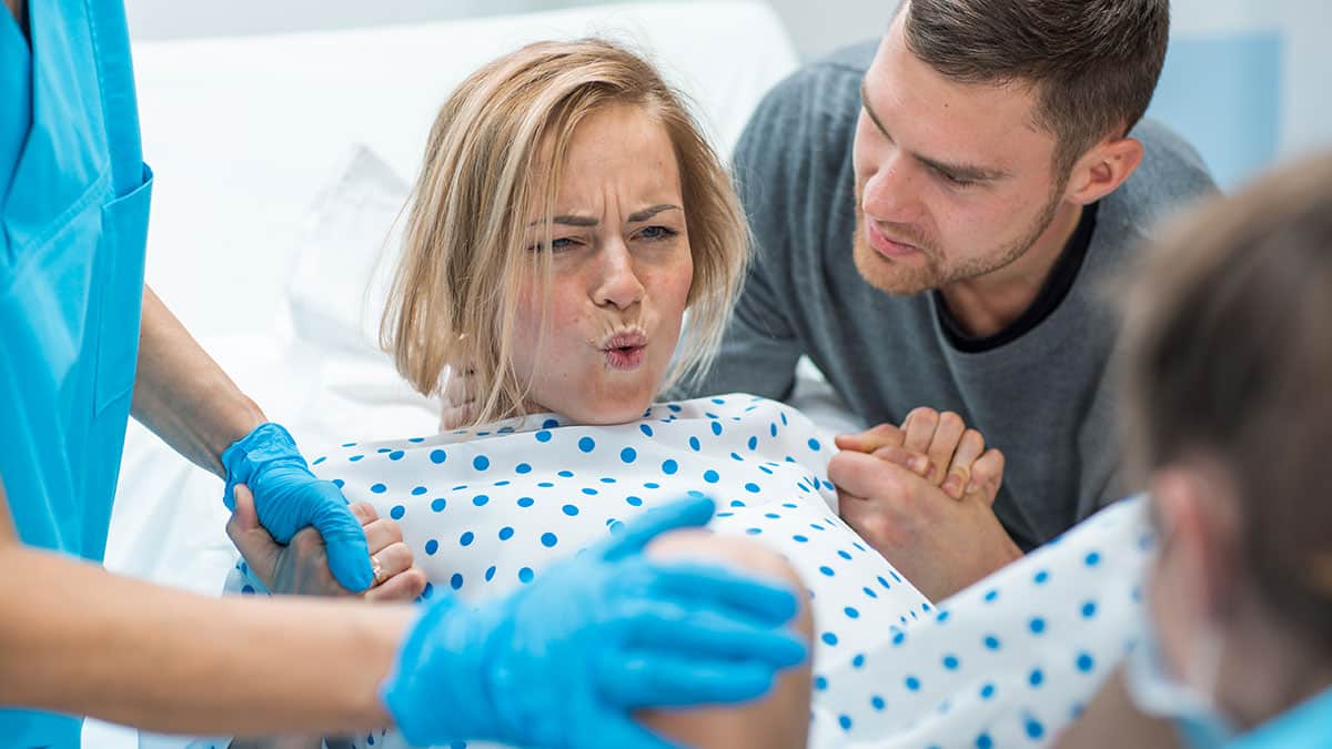 blonde pregnant woman in labor delivering baby pushing photo