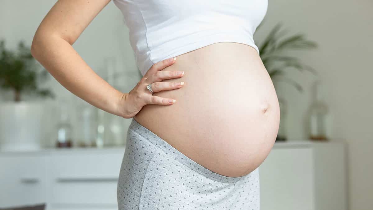 woman nine months pregnant uncovered belly