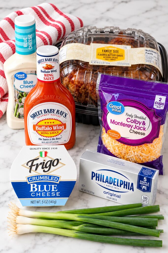 Ingredients for easy buffalo chicken dip, including rotisserie chicken, buffalo sauce, cream cheese, blue cheese, and green onions.