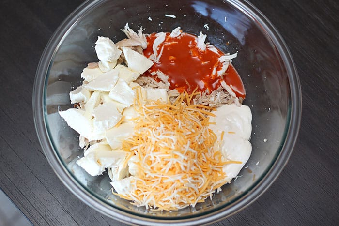 buffalo chicken dip ingredients in a glass bowl