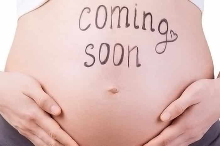 coming soon pregnancy announcement written on stomach