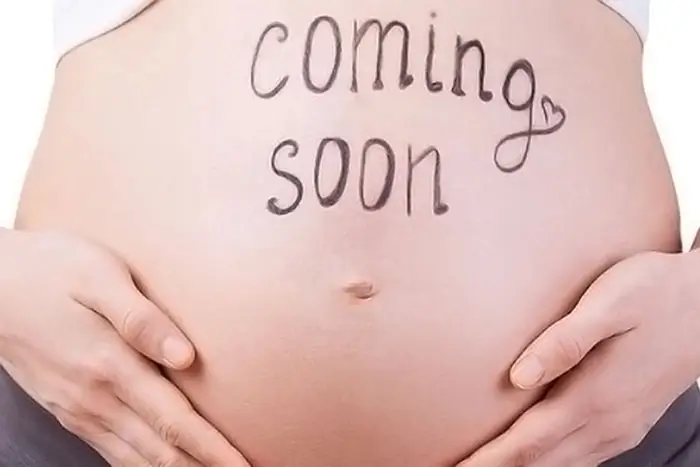 coming soon pregnancy announcement written on stomach