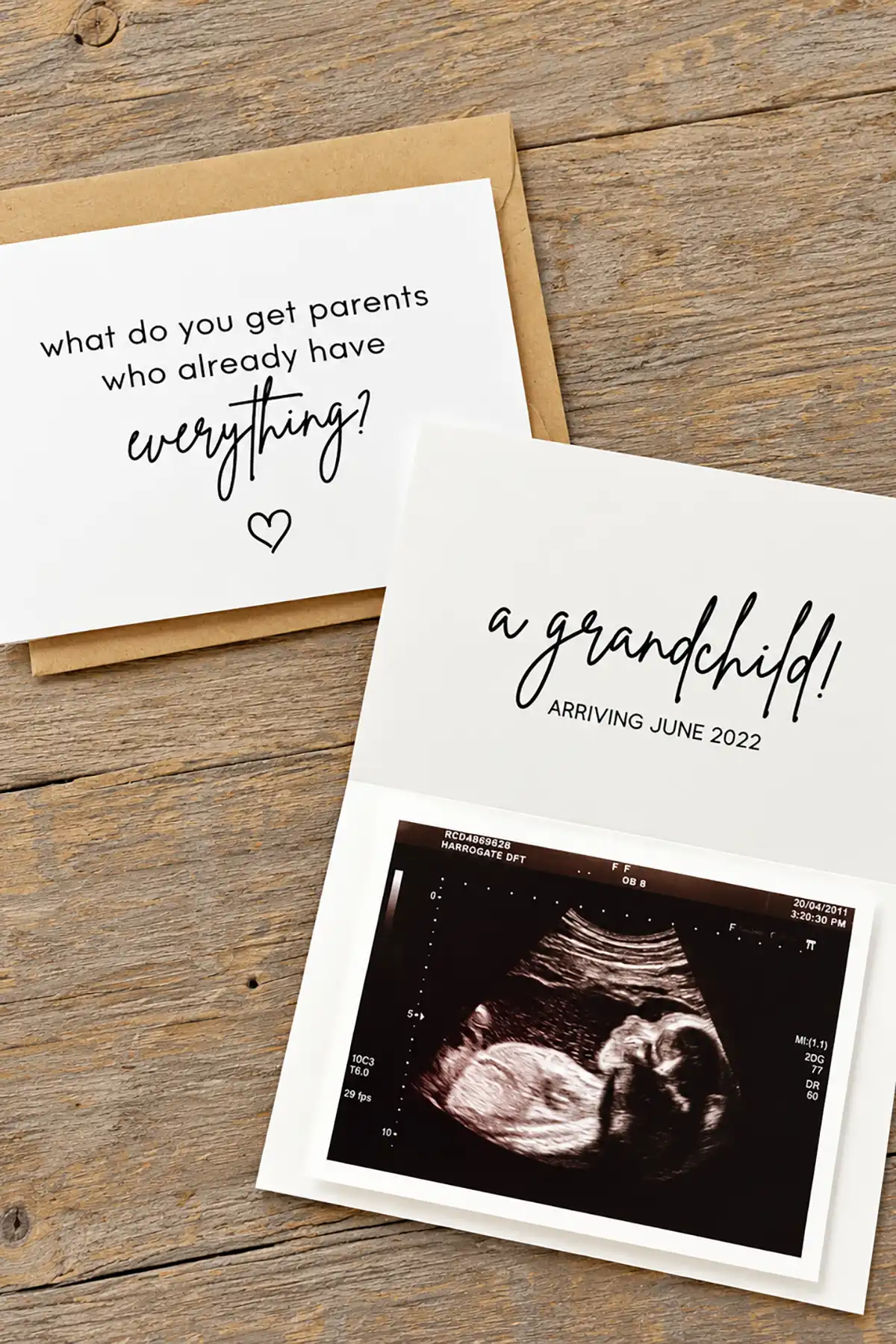 Pregnancy announcement cards revealing a grandchild arriving June 2022 with an ultrasound photo on a rustic wooden table.