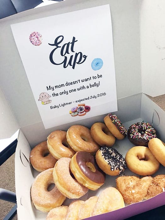 box of donuts with a sign reading "Eat Up: my mom doesn't want to be the only one with a belly!"