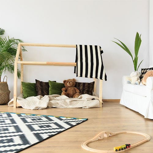 Montessori toddler room with plants and natural wood furniture