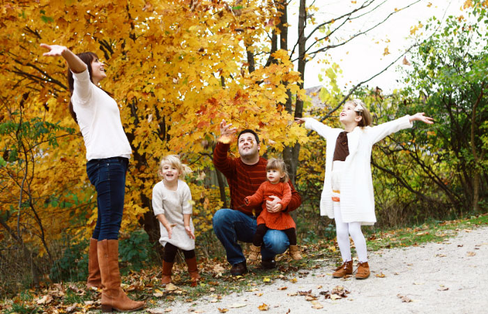 family of five playing with leaves for fall family portraits