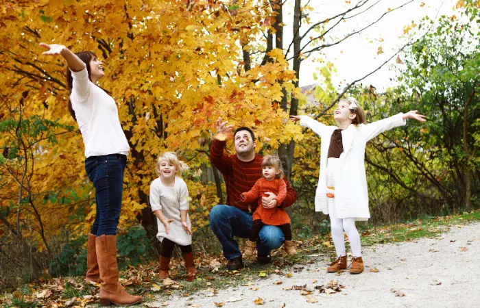 family of five playing with leaves for fall family portraits