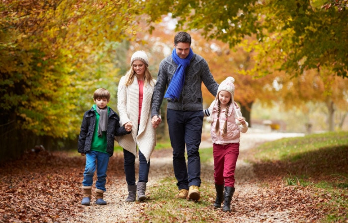 family of four walking down a path in the fall