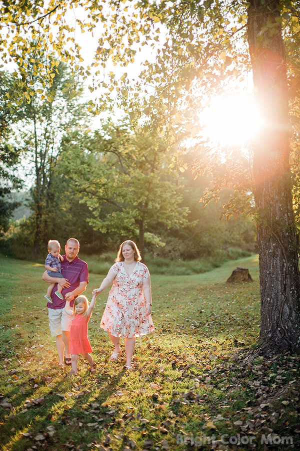 family with plus size mom standing under giant tree for fall family pics