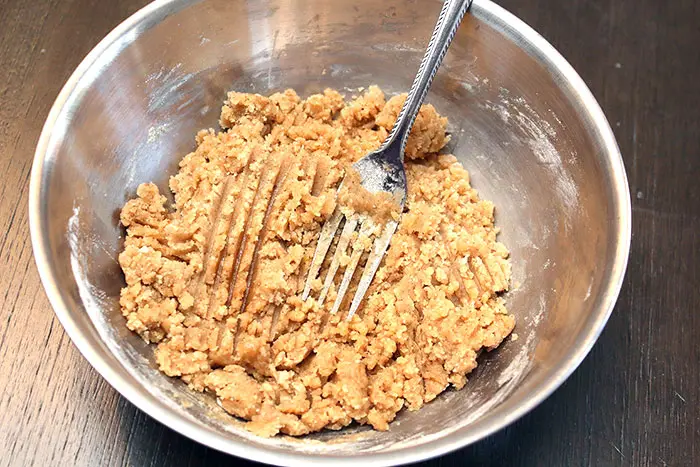 fork mashing streusel topping together