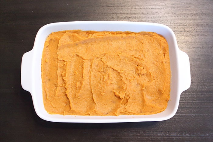 mashed sweet potato spread evenly throughout a casserole dish