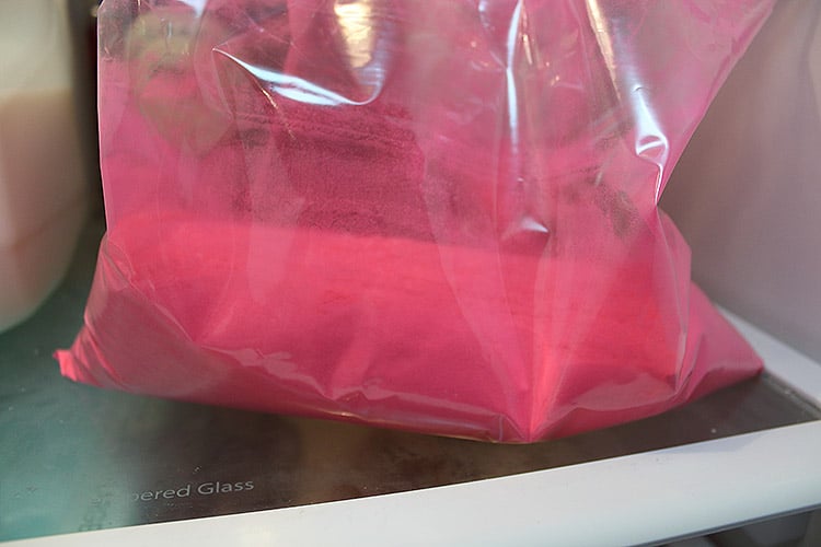 homemade pink gender reveal powder in a ziplock bag in the fridge