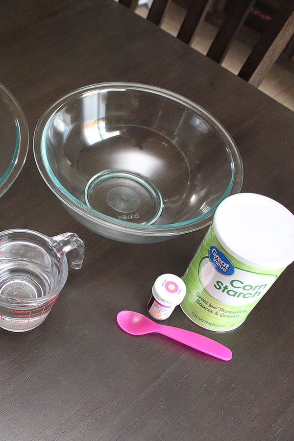 supplies needed to DIY gender reveal powder include glass bowl, cornstarch, icing coloring, and water