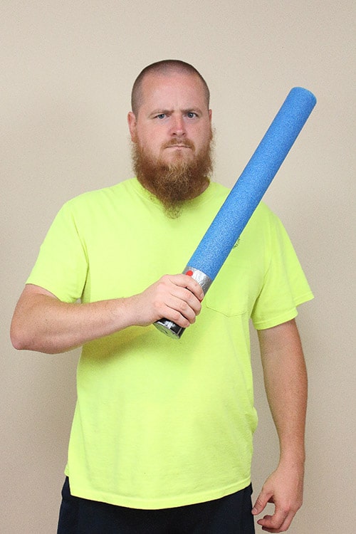 man holding a blue foam lightsaber made to look like Anakin Skywalker's