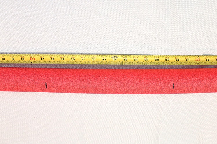 measuring tape showing where to mark a pool noodle to create Darth Maul's hilt