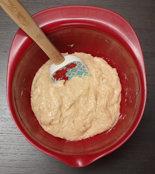 mixed muffin batter in a red mixing bowl with a Pioneer Woman spatula