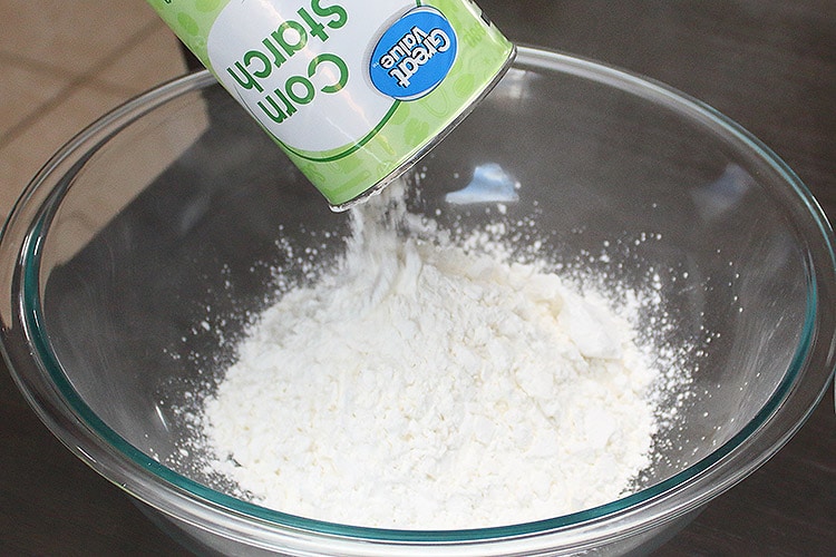 cornstarch being poured into a glass bowl