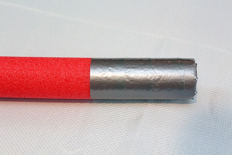 silver duct tape wrapped on end of pool noodle to create a metal-looking hilt
