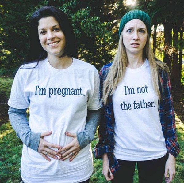 lesbian couple wearing t-shirts that say "I'm pregnant" and "I'm not the father" to announce their pregnancy
