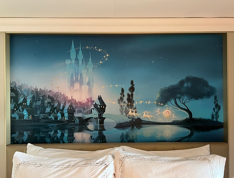 Cinderella wall art hanging over the queen bed in a Disney Wish stateroom