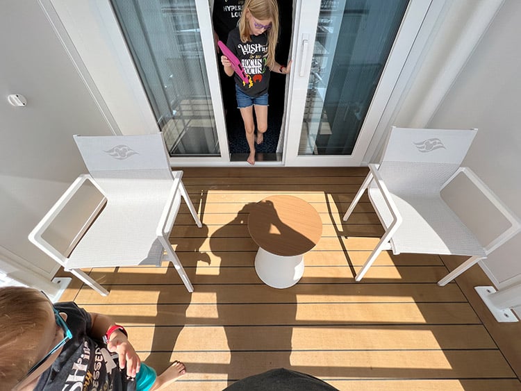 a child stepping out onto the extended verandah of a Disney Wish stateroom