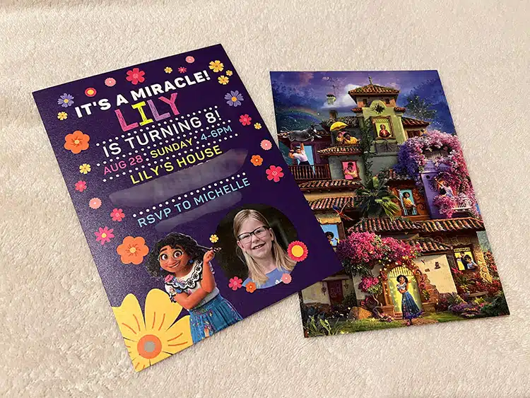 two copies of a printed Encanto birthday invitation with photo, one side showing party details and the other showing Casita and the family Madrigal as a full-page image on the reverse