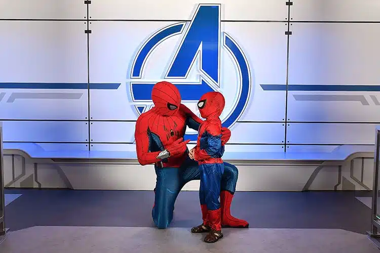 Spider-Man kneeling to talk to a young boy dressed as Spider-man on the Disney Wish