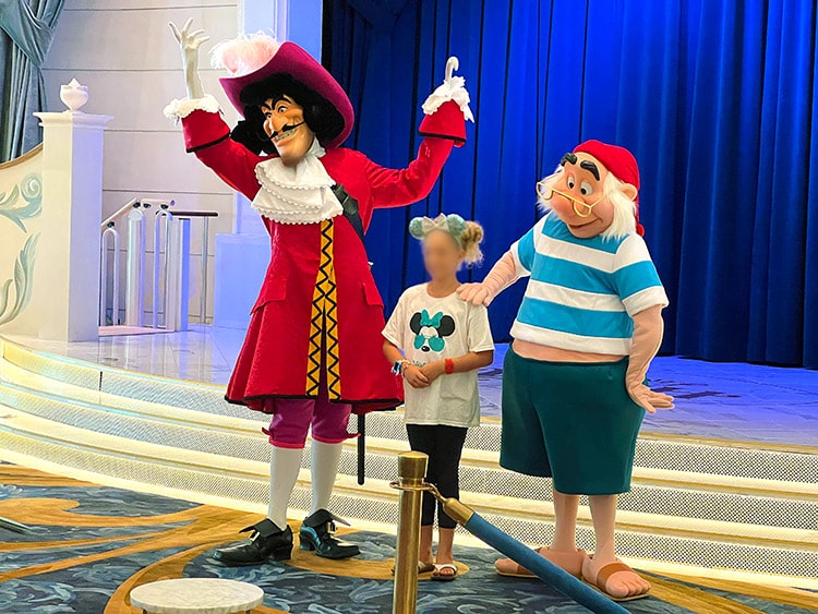Captain Hook and Mr. Smee posing with a child on the Disney Wish ship