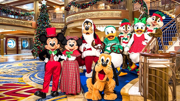 group photo of characters in Christmas outfits on a Disney cruise ship