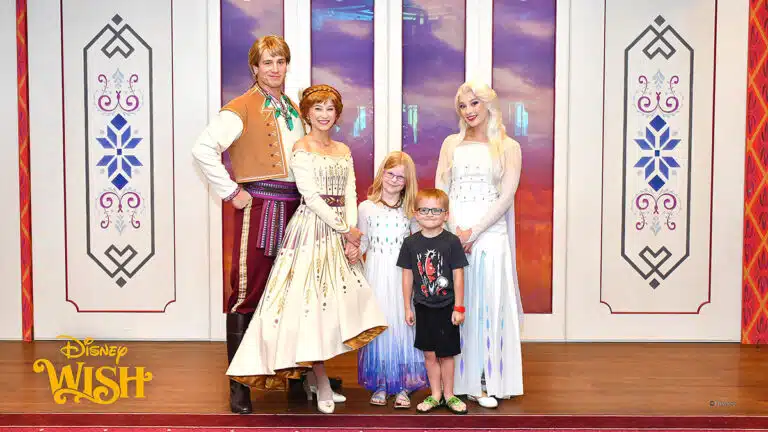 a boy and girl posing with the characters Kristoff, Anna, and Elsa on the Disney Wish ship