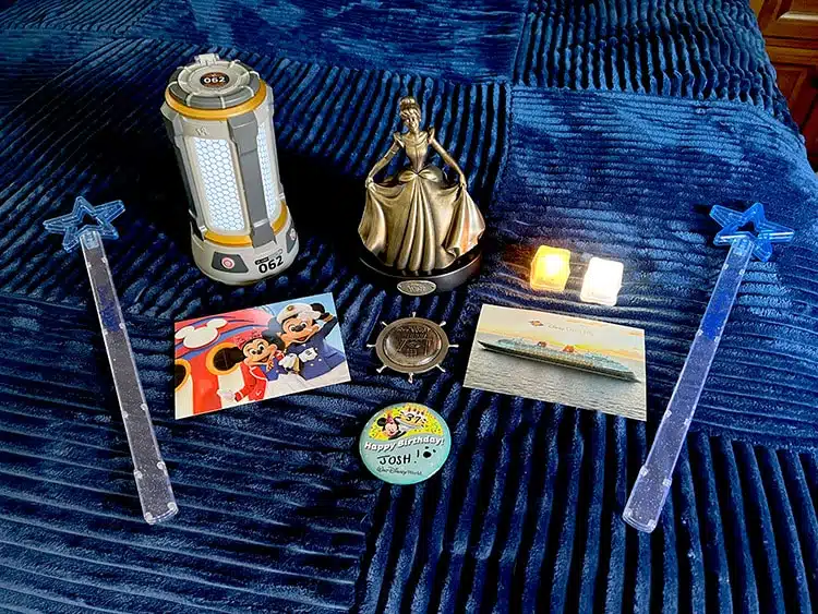 collection of souvenirs from a Disney vacation, including Wish wands, a Quantum Core cup, and bronze Cinderella statue from Disney Wish