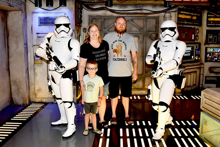 a family posing with Storm Troopers inside Star Wars: Cargo Bay on Disney Wish