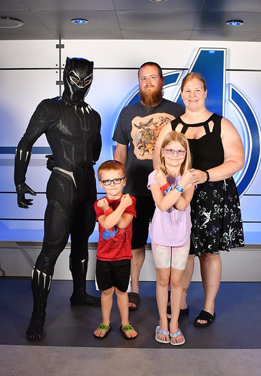 a family posing with Black Panther on the Disney Wish