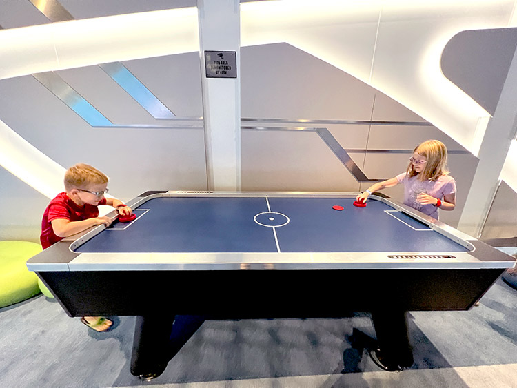 wide view of two children playing air hockey