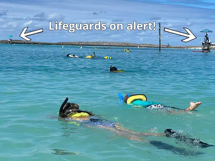 photo of snorkelers in Castaway Cay with arrows pointing out lifeguards stationed in the water