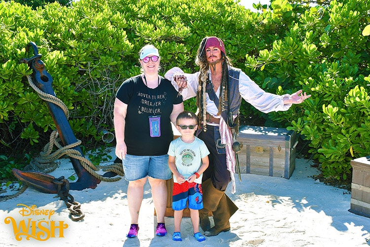 a mother and son posing with Captain Jack Sparrow on Castaway Cay