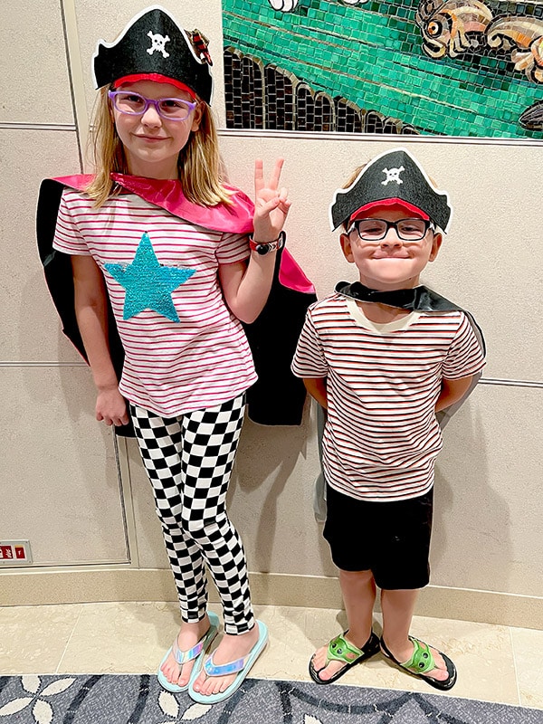 a boy and girl wearing pirate hats and capes for Pirate Night on the Disney Wish